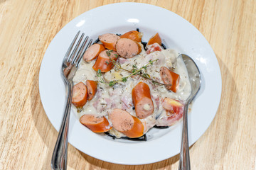 Pasta Carbonara with Sausage, Bacon and Prosciutto on wooden table.