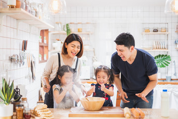 Asian family enjoy playing and cooking food in kitchen at home