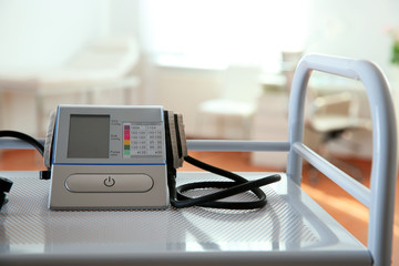 Modern blood pressure monitor on cart in medical office © New Africa