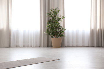 Grey yoga mat on floor in spacious room