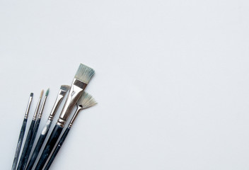 Brushes on canvas. Various paintbrushes on a white background. Space for text.