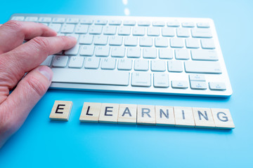 e-Learning and online education concept with text - E-learning r key on a white computer keyboard viewed at a high angle with blur vignette for focus.