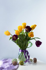 bouquet of tulips in a vase on the table, light background, postcard, spring