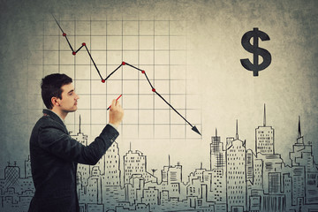 Businessman analyst gives pessimistic prognosis of COVID-19 impact to the future world economics, drawing decline graph of stock market. Global finance collapse, recession concept. Real estate crisis.