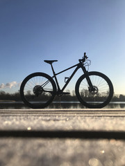 Fototapeta na wymiar Mountain bike on the beach against colorful sunset