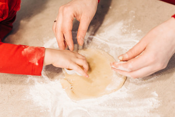 Child cuts out cookies from dough