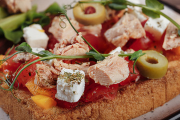 sandwich with tuna and feta, cherry tomatoes olives close-up