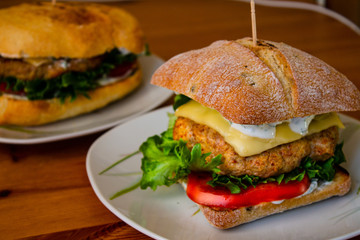 Juicy hamburger with Turkey cutlet with spices lettuce, fresh tomatoes and pickled cucumber prepared at home