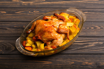 Grilled chicken with baked potato on a wooden table