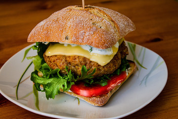 Juicy hamburger with Turkey cutlet with spices lettuce, fresh tomatoes and pickled cucumber prepared at home