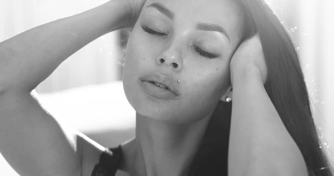 Portrait of beauty brunette woman in black lingerie posing on the bed - black and white video in slow motion