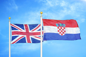 United Kingdom and Croatia two flags on flagpoles and blue cloudy sky
