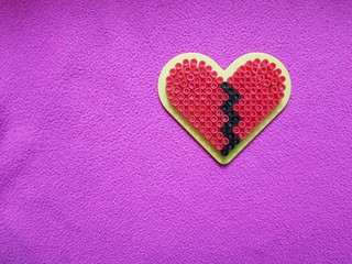 The colorful mosaic is laid out in the shape of a broken heart.