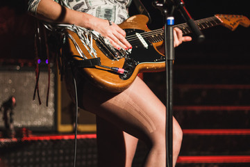 woman playing electric guitar on stage