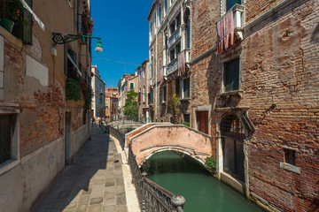 View of narrow Canal with boats and gondolas in Venice, Italy