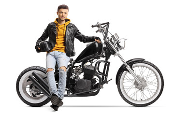 Fototapeta na wymiar Guy biker holding a helmet and sitting on a custom motorbike