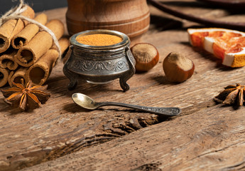 Ground cinnamon, cinnamon sticks, on old wooden background