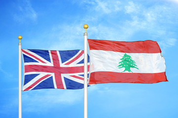 United Kingdom and Lebanon two flags on flagpoles and blue cloudy sky