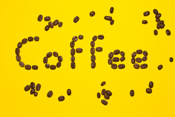 Coffee lettering written with coffee beans on yellow background