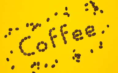 Coffee lettering written with coffee beans on yellow background