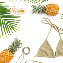 Tropical concept. Pineapples and bikini on white background. Flat lay