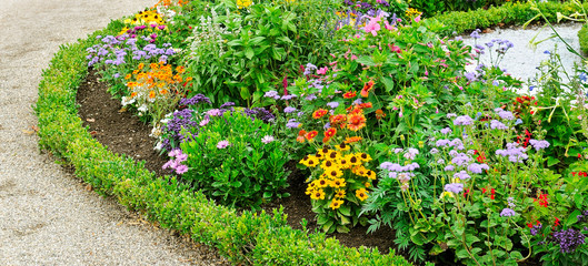 Scenic View of Colourful Flowerbeds, a Lush Green Lawn. Wide photo .