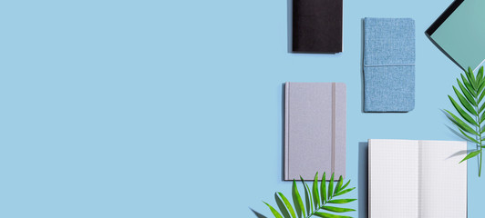 Collection of notebooks with tropical leaves - flat lay