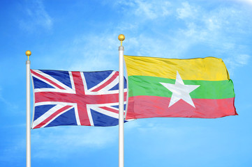 United Kingdom and Myanmar two flags on flagpoles and blue cloudy sky