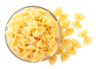 Raw pasta butterflies in a glass plate on a white. Isolated, top view.