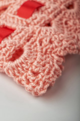 A close up image of metal crochet hooks and crochet cotton dish cloths.