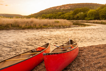 Obraz premium Red Canoes Beside The Brazos River at Sunset, Near Palo Pinto,Texas, USA
