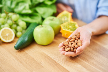 Healthy adult woman with green food in the kitchen
