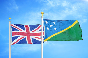 United Kingdom and Solomon Islands two flags on flagpoles and blue cloudy sky