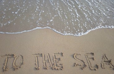 Title To the sea on a sandy beach with a sea wave above. Vacation concept.