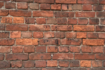 old brick wall with crumbling bricks from time to time