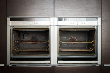 Obraz premium modern high standard kitchen with dark furniture and two ovens