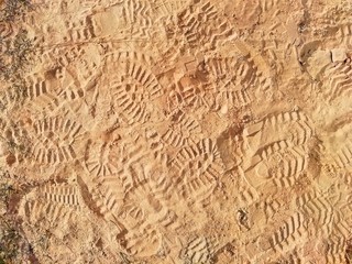 background of a sandy surface with many boot marks on it