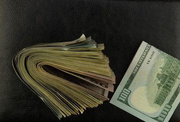 cash dollars lie in a mess on black leather background, stock image of cash american currency