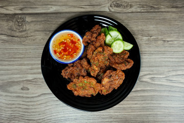 Fried fish paste balls in white plate on wooden table, Top view. Thai traditional style foods.