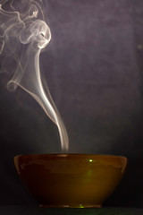 Steaming clay bowl with hot soup