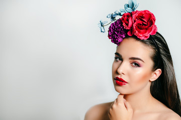 Naklejka premium Pretty spring girl with flowers on her head and bright makeup. May calendar beautiful girl.