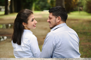 Fototapeta premium Cute couple on a park bench looking at each other