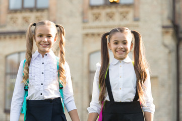 Ending of school year. Lucky to meet each other. Cheerful smart schoolgirls. Happy schoolgirls outdoors. Small schoolgirls wear school uniform. Cute schoolgirls with long ponytails looking charming
