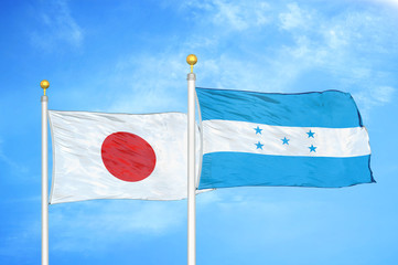 Japan and Honduras two flags on flagpoles and blue cloudy sky