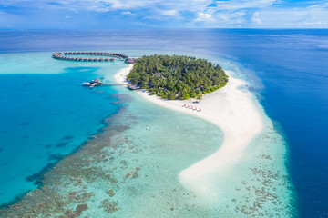 Aerial landscape of Maldives beach. Tropical panorama, luxury water villa resort with wooden pier or jetty. Luxury travel destination background for summer holiday and vacation concept.
