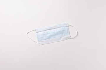 Medical mask on white background. Coronavirus pandemic. Flat lay. Surgical protective mask.