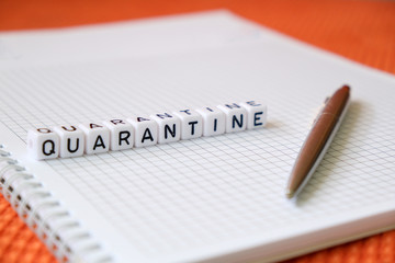 Text "Quarantine", word made of cubic letters and luxury pen on a white paper note pad background.