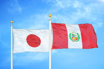 Japan and Peru two flags on flagpoles and blue cloudy sky