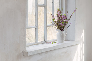 Fototapeta na wymiar daphne flowers in vase on vintage windowsill