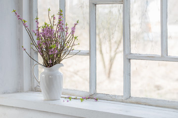 daphne flowers in vase on vintage windowsill